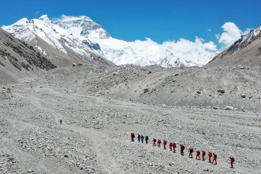FILE - In this May 16, 2020 aerial photo released by Xinhua News Agency, Chinese surveyors hike toward a higher spot from the base camp on Mount Qomolangma at an altitude of 5,200 meters. (Jigme Dorje/Xinhua via AP, File) FILE - In this May 16, 2020 aerial photo released by Xinhua News Agency, Chinese surveyors hike toward a higher spot from the base camp on Mount Qomolangma at an altitude of 5,200 meters. (Jigme Dorje/Xinhua via AP, File)