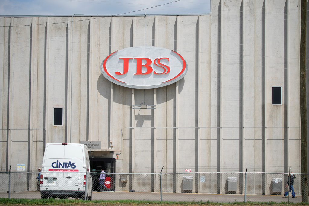 FILE - Employees walk in front of the entrance to the JBS meat processing plant, July 23, 2021, in Greeley, Colo. (AP Photo/David Zalubowski, File)