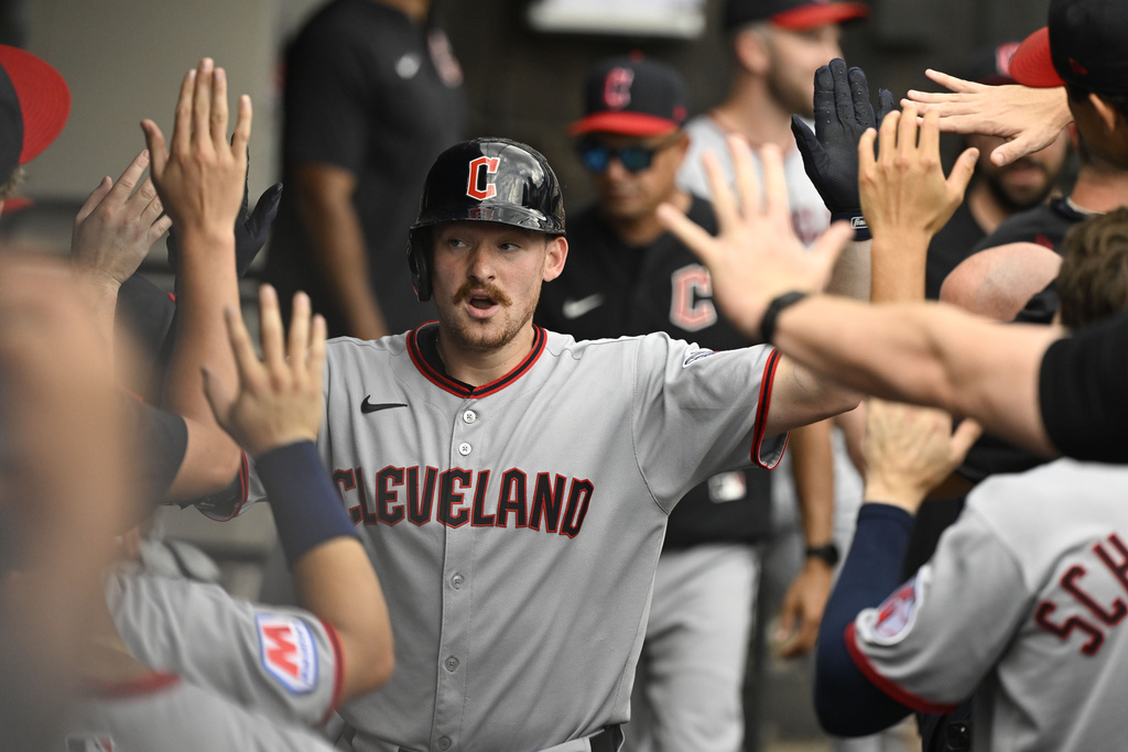Cleveland Guardians' Kyle Manzardo celebrates in the dugout after hitting a home run during the seventh inning of a baseball game against the Chicago White Sox, Sunday, Aug. 10, 2025, in Chicago. (AP Photo/Matt Marton)