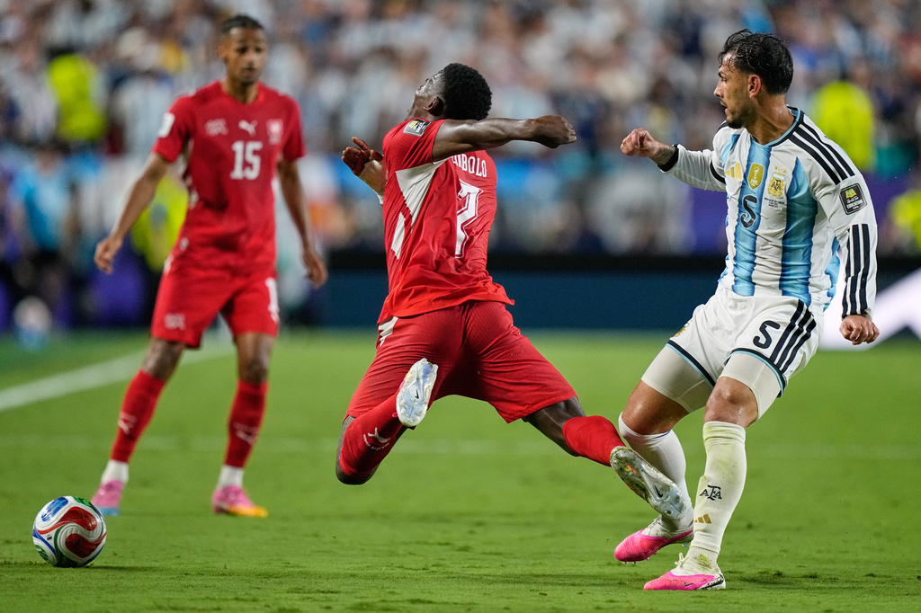 Switzerland's Breel Embolo (7) reacts as he dives in a challenge from Argentina's Leandro Paredes (5) for which he got a second yellow card during the World Cup quarterfinal soccer match between Argentina and Switzerland in Kansas City, Mo., Saturday, July 11, 2026. (AP Photo/Ashley Landis)