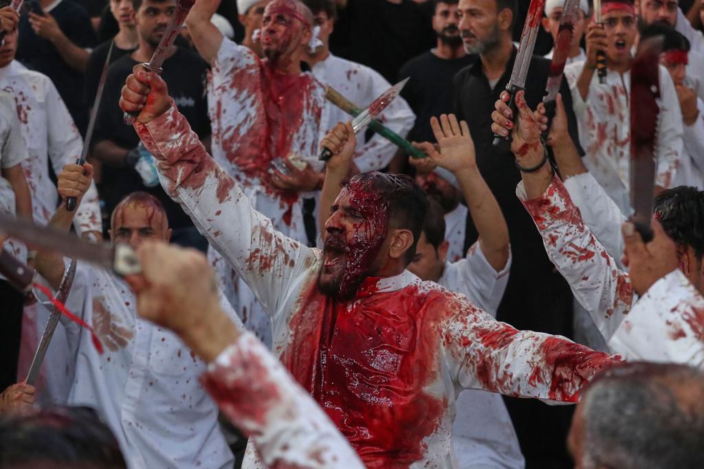 EDS NOTE: GRAPHIC CONTENT - Shiite men bleed from self-inflicted wounds after cutting their heads with swords during a procession to mark the Muslim festival of Ashoura, on the 10th day of Muharram, in Basra, Iraq, Friday, June 26, 2026. (AP Photo/Ali Rahim)