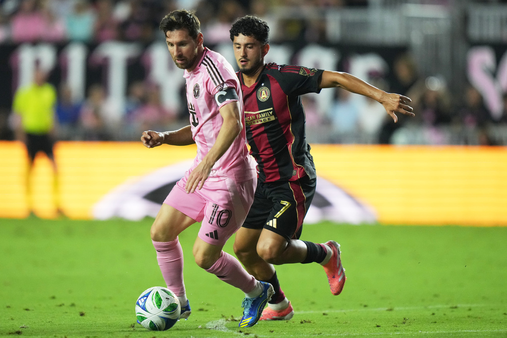 Inter Miami forward Lionel Messi (10) runs with the ball as Atlanta United midfielder Steven Alzate (7) defends during the first half of an MLS soccer match, Saturday, Oct. 11, 2025, in Fort Lauderdale, Fla. (AP Photo/Lynne Sladky)