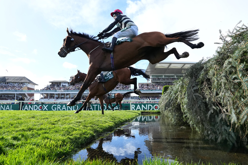 Top of the Bill ridden by Toby McCain-Mitchell, front, clears a fence during the Grand National horse race at Aintree racecourse in Liverpool, Saturday, April 11, 2026. (AP Photo/Jon Super)