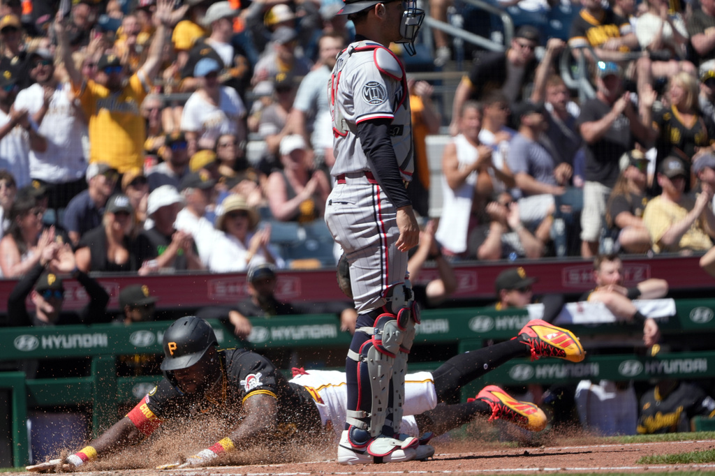 Pittsburgh Pirates' Oneil Cruz slides into home plate past Minnesota Twins catcher Alex Jackson scoring on Henry Davis' single in the fifth inning of a baseball game in Pittsburgh, Sunday, May 31, 2026. (AP Photo/Tom E. Puskar)