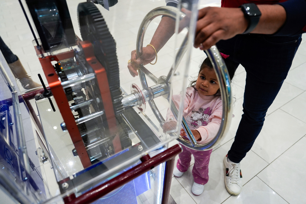 FILE - A girl uses a penny press machine at the American Dream mall, March 2, 2025, in East Rutherford, N.J. (AP Photo/Julia Demaree Nikhinson, File)
