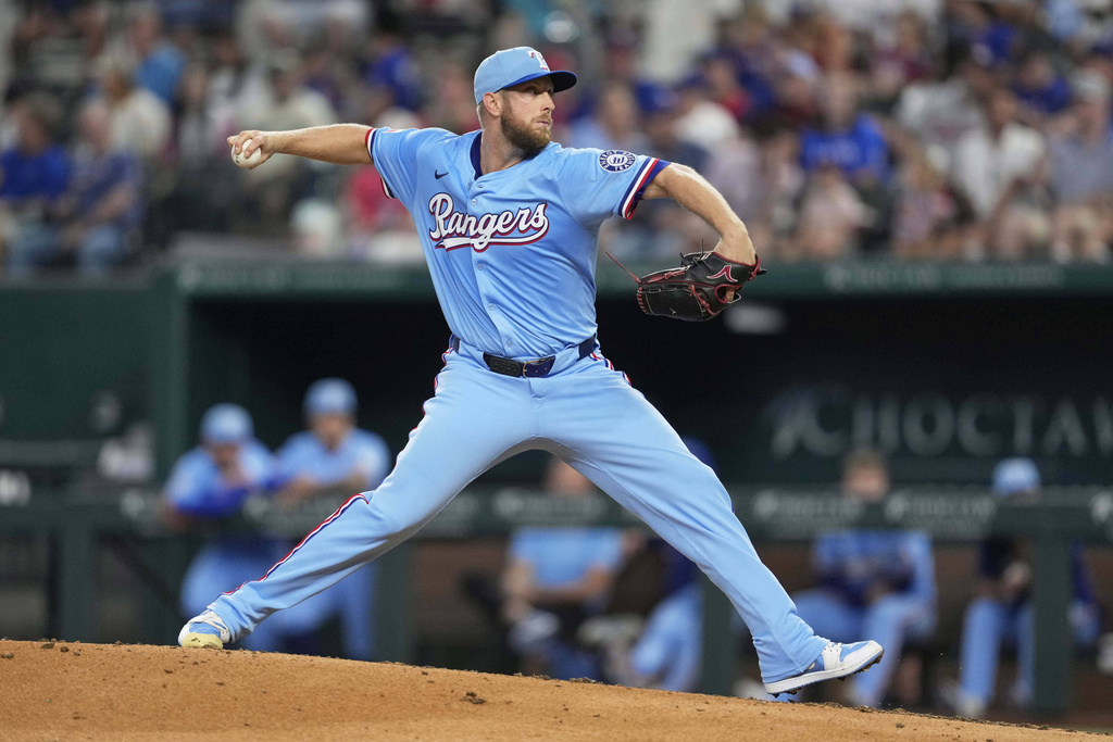 Texas Rangers starting pitcher Merrill Kelly throws to the Cleveland Guardians in the third inning of a baseball game Sunday, Aug. 24, 2025, in Arlington, Texas. (AP Photo/Tony Gutierrez)