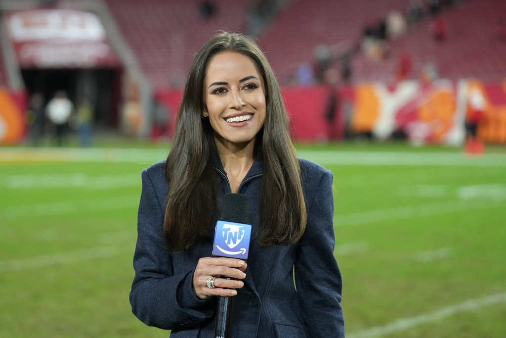 FILE - NFL sidelines reporter Kaylee Hartung reports to the camera following an NFL football game between the Atlanta Falcons and the Tampa Bay Buccaneers, Thursday, Dec 11, 2025, in Tampa, Fla. (AP Photo/Peter Joneleit, file)