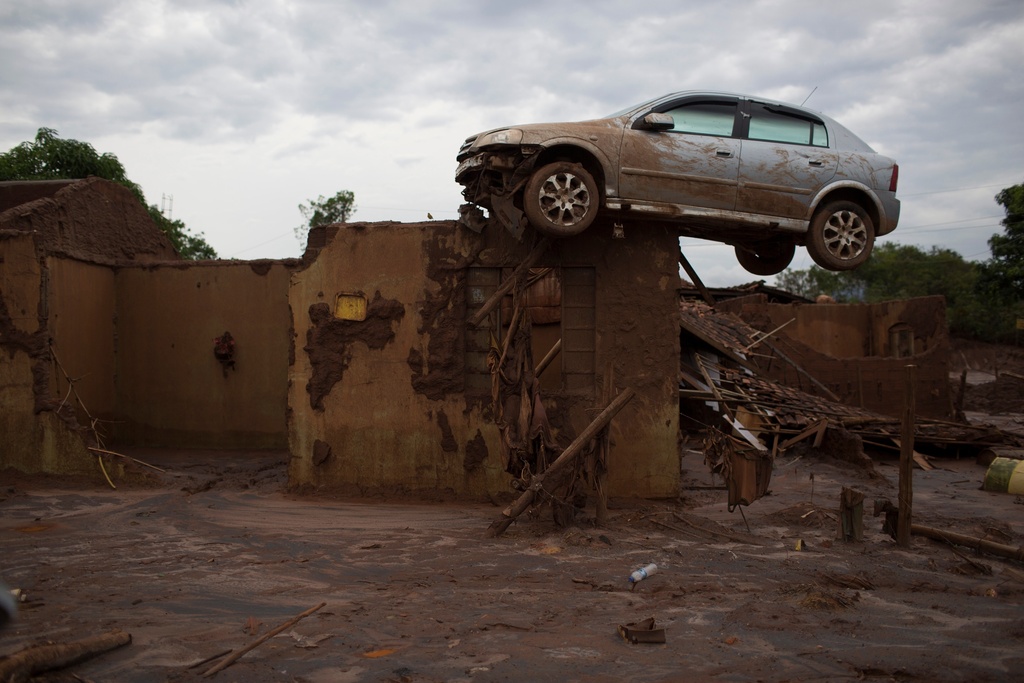 FILE - A car sits on top of a wall of a home, destroyed when a dam burst in Bento Rodrigues, Brazil, on Nov. 23, 2015. (AP Photo/Leo Correa)