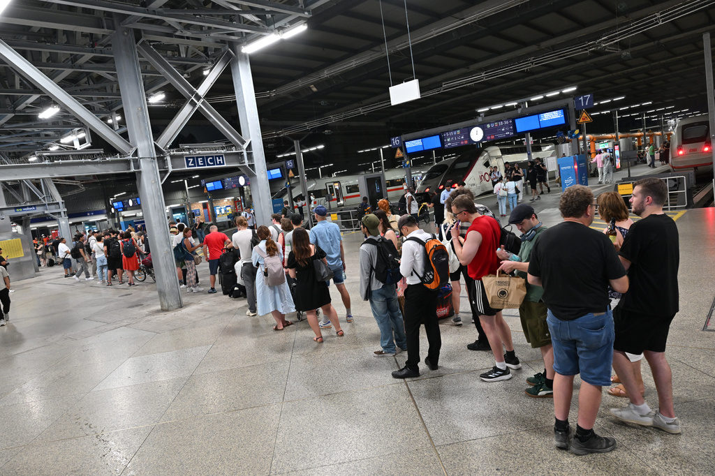 Passengers stand in line at the DB information desk at the Munich train station, Tuesday, June 23, 2026. (Peter Kneffel/dpa via AP)