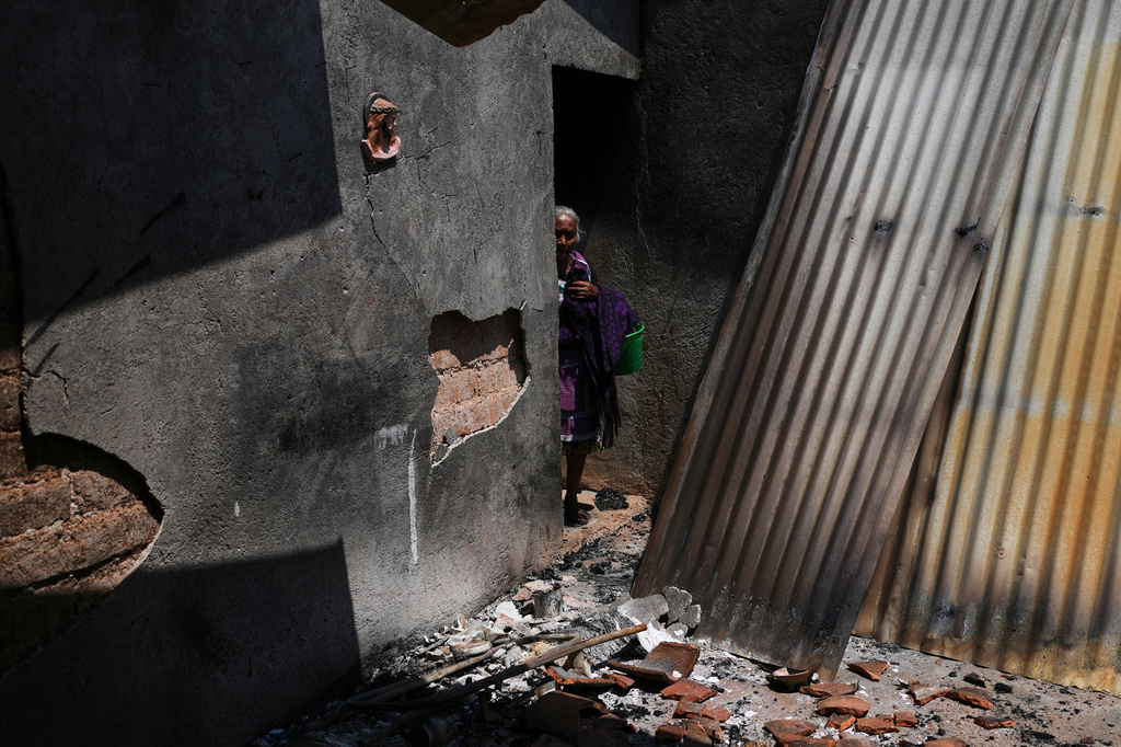 FILE - Maria Anastasia Cabrera walks through the ruins of her home after armed attacks by local criminal groups forced dozens of residents to flee, in Tula, Mexico, May 15, 2026. (AP Photo/Marco Ugarte, File)