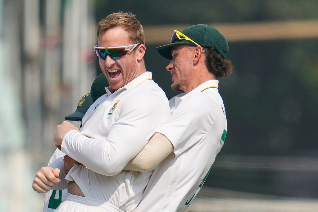 South Africa's Simon Harmer, left, celebrates with teammate Marco Jansen after the dismissal of India's Washington Sundar on the second day of the first cricket test match between India and South Africa in Kolkata, India, Saturday, Nov. 15, 2025. (AP Photo/Aijaz Rahi)