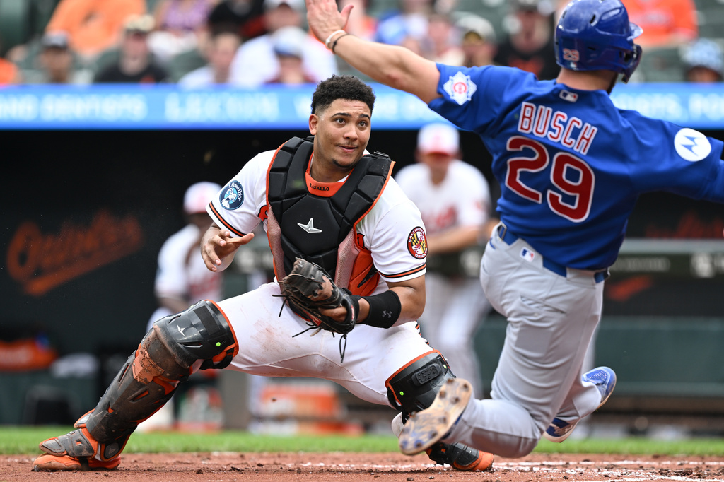 Baltimore Orioles catcher Samuel Basallo (29) looks to tag Chicago Cubs' Michael Busch (29) at the plate in the fourth inning of a baseball game, Thursday, July 9, 2026 in Baltimore. (AP Photo/Gail Burton)