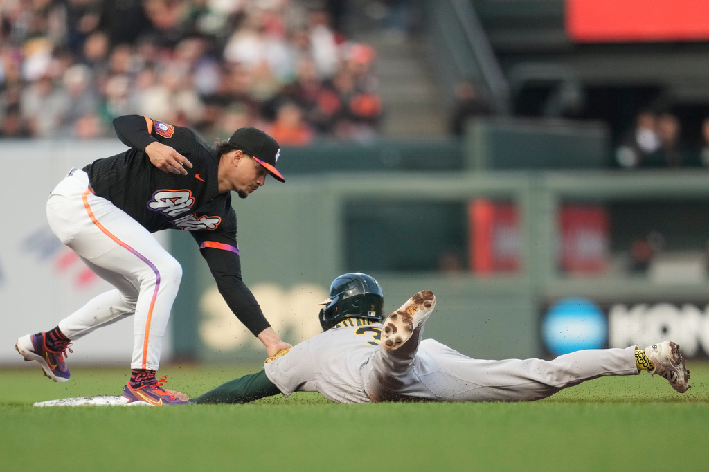 The Athletics' Max Muncy, bottom, is tagged out by San Francisco Giants shortstop Willy Adames while trying to steal second base during the third inning of a baseball game Tuesday, June 23, 2026, in San Francisco. (AP Photo/Jeff Chiu)