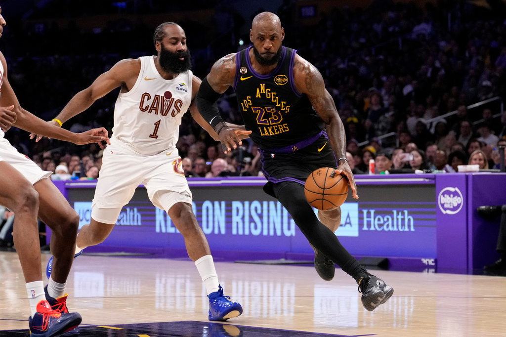 Los Angeles Lakers forward LeBron James, right, drives by Cleveland Cavaliers guard James Harden during the first half of an NBA basketball game Tuesday, March 31, 2026, in Los Angeles. (AP Photo/Mark J. Terrill)