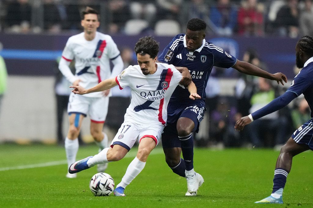 PSG's Vitinha, centre left, and Paris FC's Marshall Munetsi challenge for the ball during the French League One soccer match between Paris FC and Paris Saint-Germain in Paris, Sunday, May 17, 2026. (AP Photo/Michel Euler)