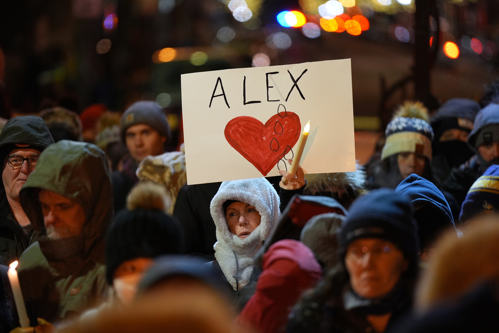 An attendee holds a sign during a vigil where Alex Pretti was shot and killed by federal immigration enforcement in Minneapolis, on Wednesday, Jan. 28, 2026. (AP Photo/Adam Gray)