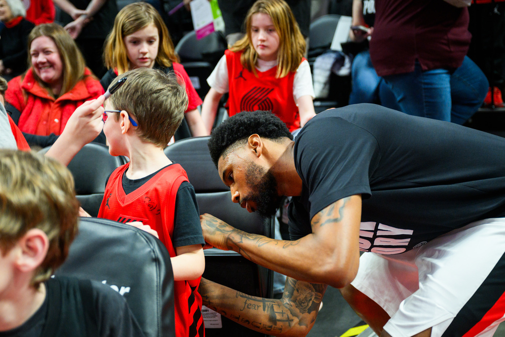 Portland Trail Blazers guard Blake Wesley, right, gives autographs during warmups before an NBA basketball game against the Memphis Grizzlies, Friday, Feb. 6, 2026, in Portland, Ore. (AP Photo/Molly J. Smith)