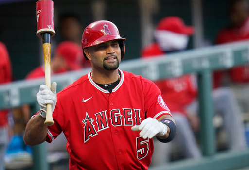 FILE - Los Angeles Angels designated hitter Albert Pujols waves to players in the Colorado Rockies dugout in the second inning of a baseball game, Sept. 12, 2020, in Denver. (AP Photo/David Zalubowski, File) FILE - Los Angeles Angels designated hitter Albert Pujols waves to players in the Colorado Rockies dugout in the second inning of a baseball game, Sept. 12, 2020, in Denver. (AP Photo/David Zalubowski, File)
