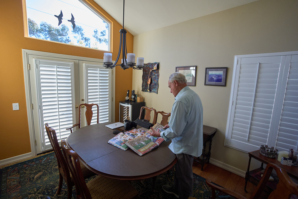 Photographer John Biever, who has shot every Super Bowl NFL football game, looks over images he has made at previous bowl games at his home Tuesday, Jan. 20, 2026, in San Diego. (AP Photo/Gregory Bull)