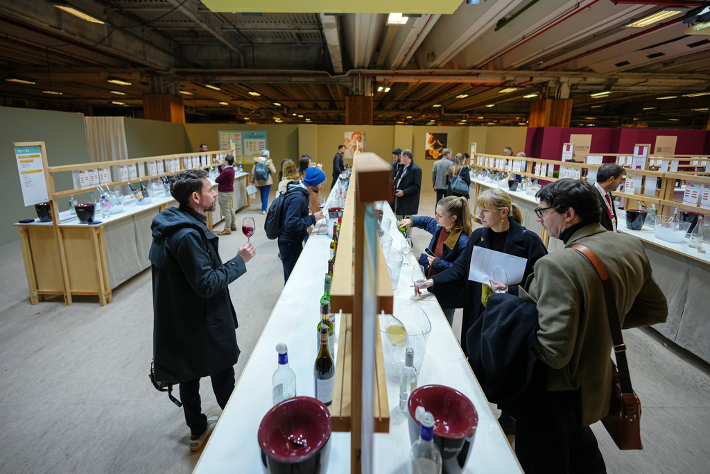 Visitors taste non-alcoholic wine at the Wine Paris 2026 fair, at the Porte de Versailles exhibition center in Paris, France, Tuesday, Feb. 10, 2026. (AP Photo/Aurelien Morissard)