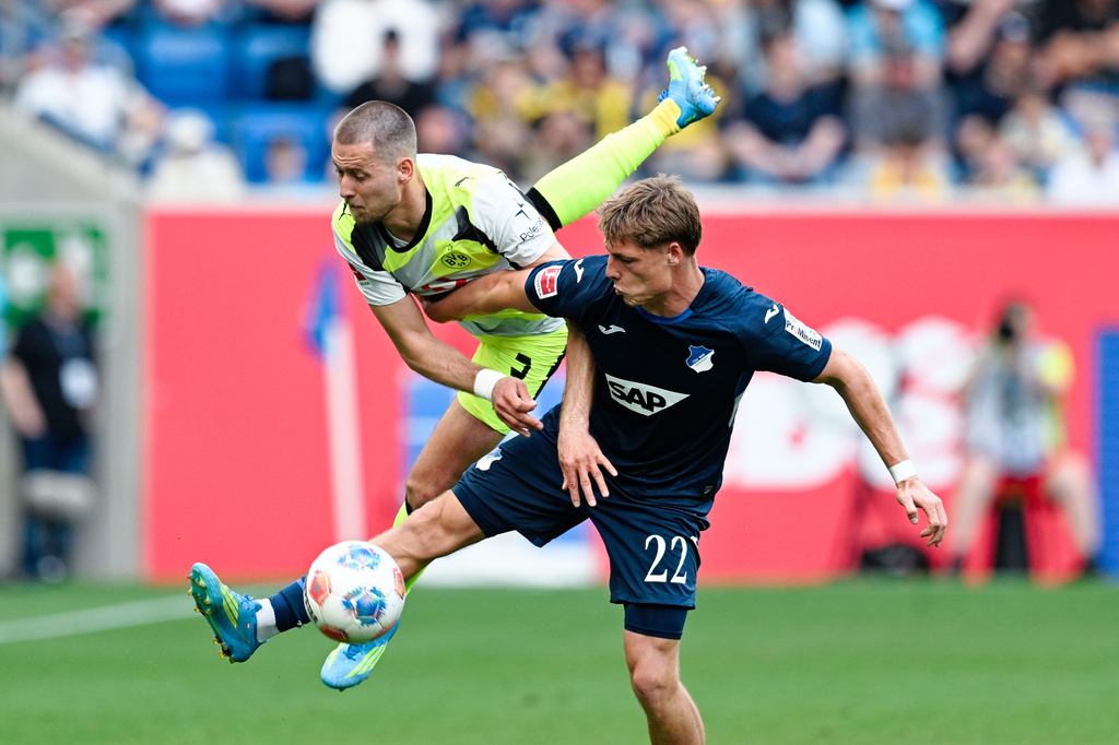 Dortmund's Waldemar Anton, left, and Hoffenheim's Alexander Prass battle for the ball during their German Bundesliga soccer match in Sinsheim, Germany, Saturday, April 18, 2026. (Uwe Anspach/dpa via AP)