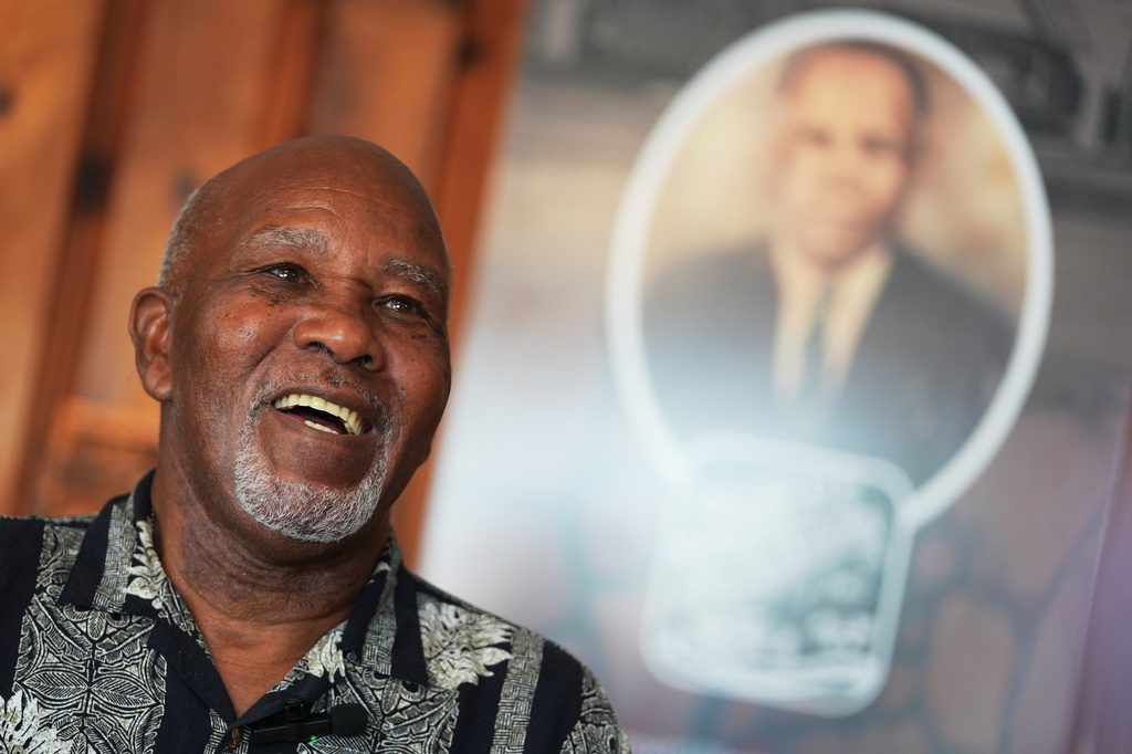 Edward Threatt, speaking in front of a photograph of his grandfather Allen Threatt Sr., is interviewed at the Threatt Filling Station along Route 66 in Luther, Okla., Wednesday, Nov. 19, 2025. (AP Photo/Julio Cortez)