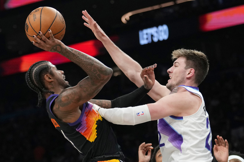 Phoenix Suns guard Jalen Green, left, goes up for a shot against Utah Jazz forward Kyle Filipowski during the first half of an NBA basketball game, Saturday, March 28, 2026, in Phoenix. (AP Photo/Ross D. Franklin)