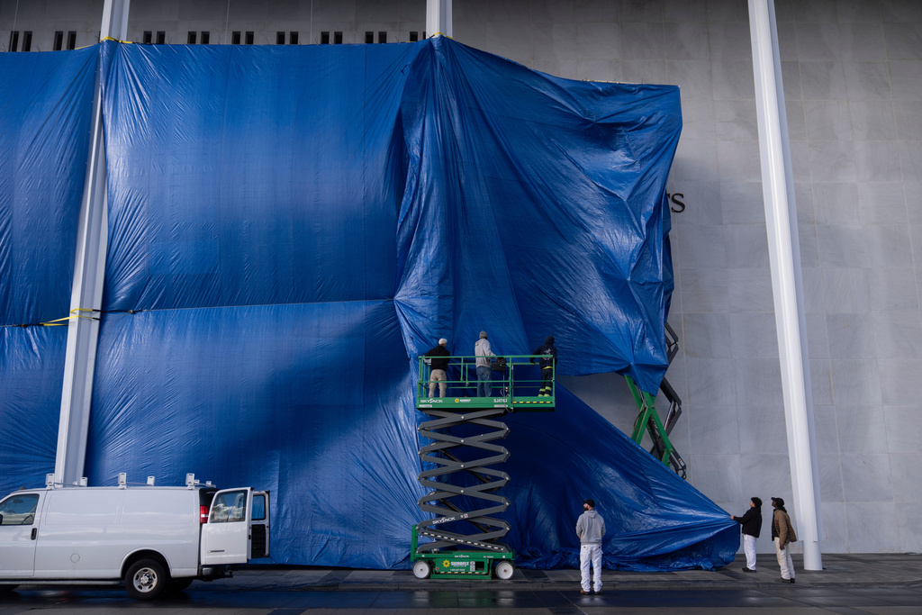 Tarps are installed in front of the sign at the Kennedy Center on Friday, Dec. 19, 2025, in Washington. (AP Photo/Mark Schiefelbein)