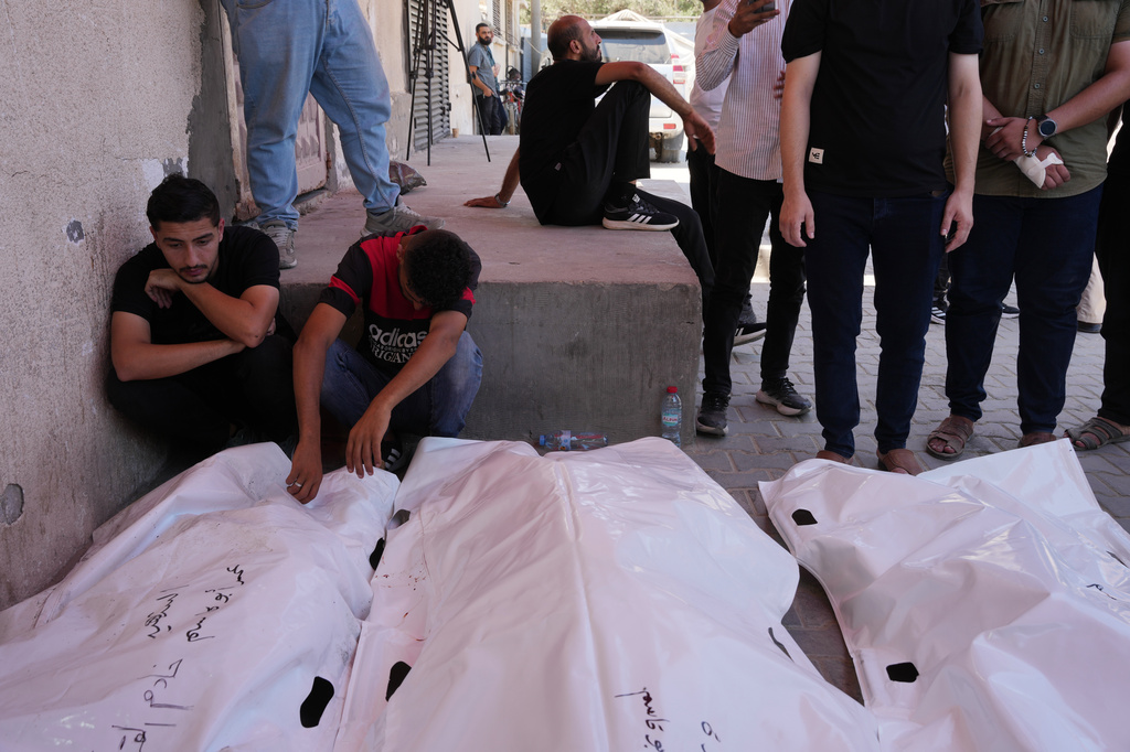 Palestinians mourn the bodies of people killed in an Israeli military strike on a residential building during their funeral at Al-Aqsa Hospital in Deir al-Balah, central Gaza Strip, Wednesday, July 15, 2026. (AP Photo/Abdel Kareem Hana)