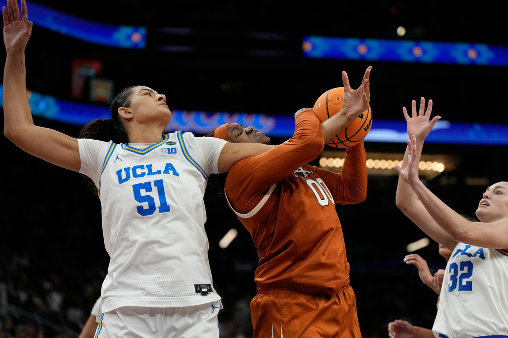 UCLA center Lauren Betts (51) and Texas center Kyla Oldacre (00) battle for the ball during the second half of a women's NCAA college basketball tournament semifinal game at the Final Four, Friday, April 3, 2026, in Phoenix. (AP Photo/Ross D. Franklin)