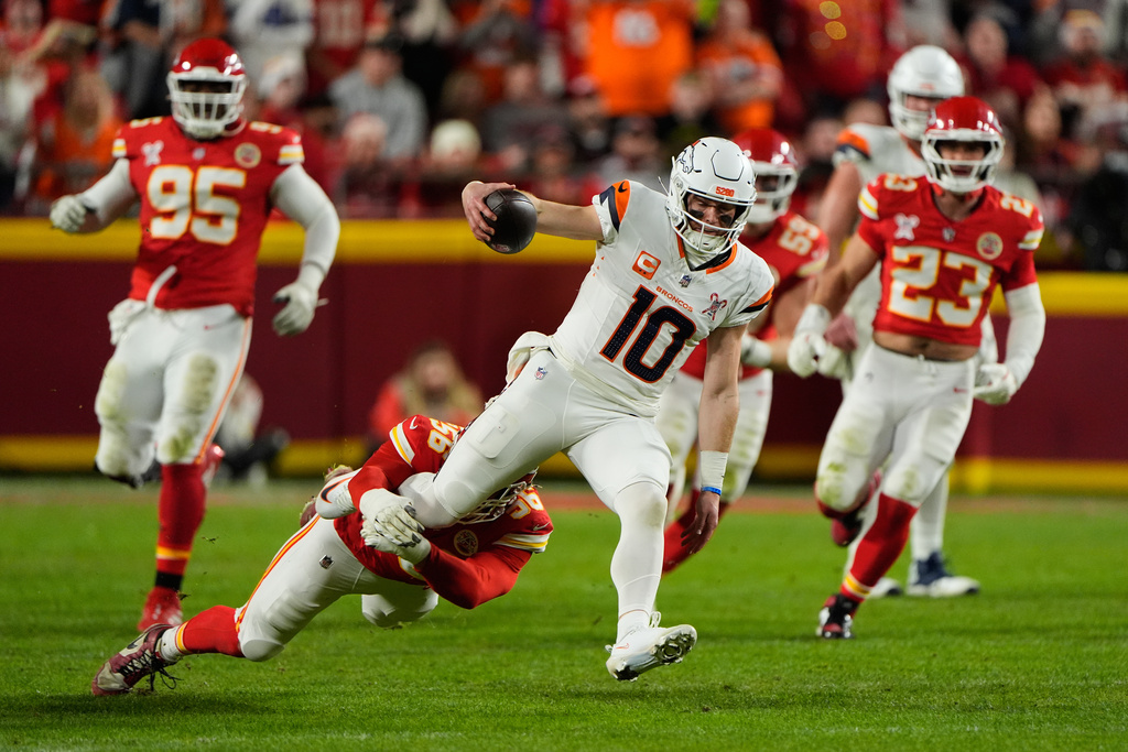 Denver Broncos quarterback Bo Nix (10) is tackled by Kansas City Chiefs defensive end George Karlaftis (56) during the first half of an NFL football game Thursday, Dec. 25, 2025, in Kansas City, Mo. (AP Photo/Charlie Riedel)