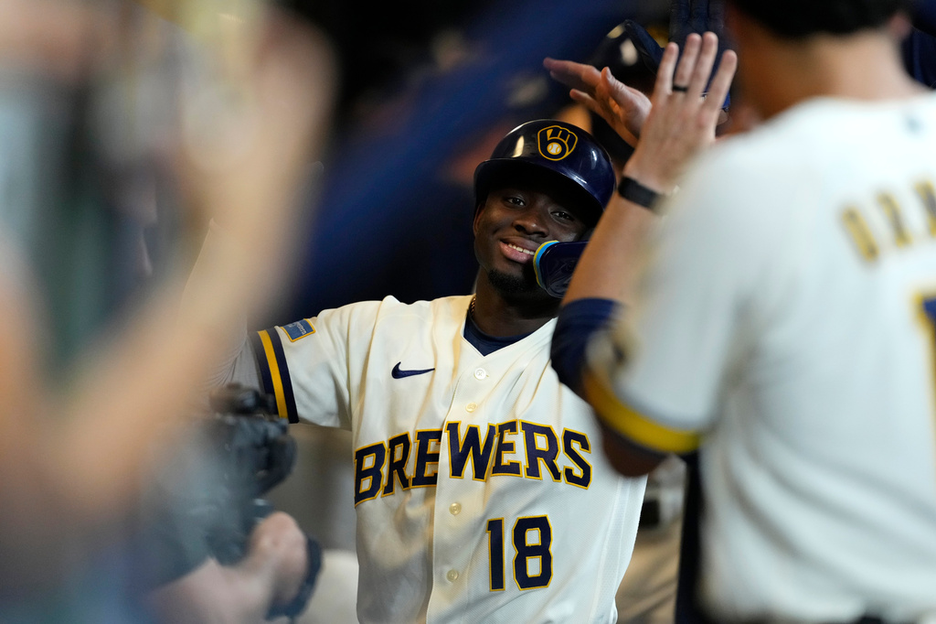 Milwaukee Brewers' Luis Lara is congratulated in the dugout after hitting a three-run home run for his first career home run during the eighth inning of a baseball game against the Seattle Mariners, Tuesday, Aug. 18, 2026, in Milwaukee. (AP Photo/Aaron Gash)
