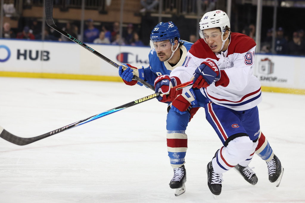 New York Rangers' Sam Carrick (39) and Montr&eacute;al Canadiens' Oliver Kapanen (91) go after the puck in the second period of an NHL hockey game, Saturday, Dec. 13, 2025, in New York. (AP Photo/Heather Khalifa)