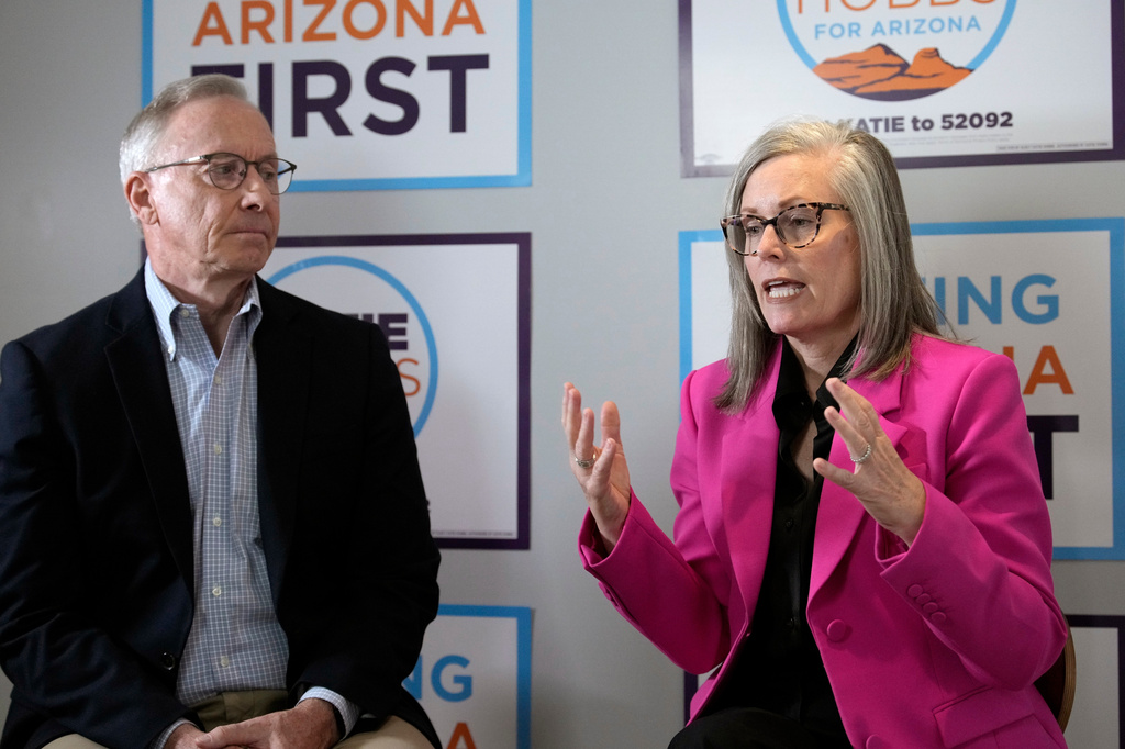 Arizona Democratic Gov. Katie Hobbs, right, sits down with her running mate for Lieutenant Governor John Giles, the former Republican Mesa, Ariz., mayor, Monday, Aug. 10, 2026, in Phoenix. (AP Photo/Ross D. Franklin)