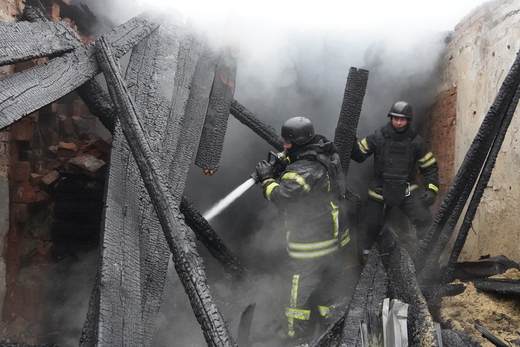 Rescue workers put out a fire of a building damaged by a Russian strike on Kharkiv, Ukraine, Wednesday, Nov. 12, 2025. (AP Photo/Andrii Marienko)