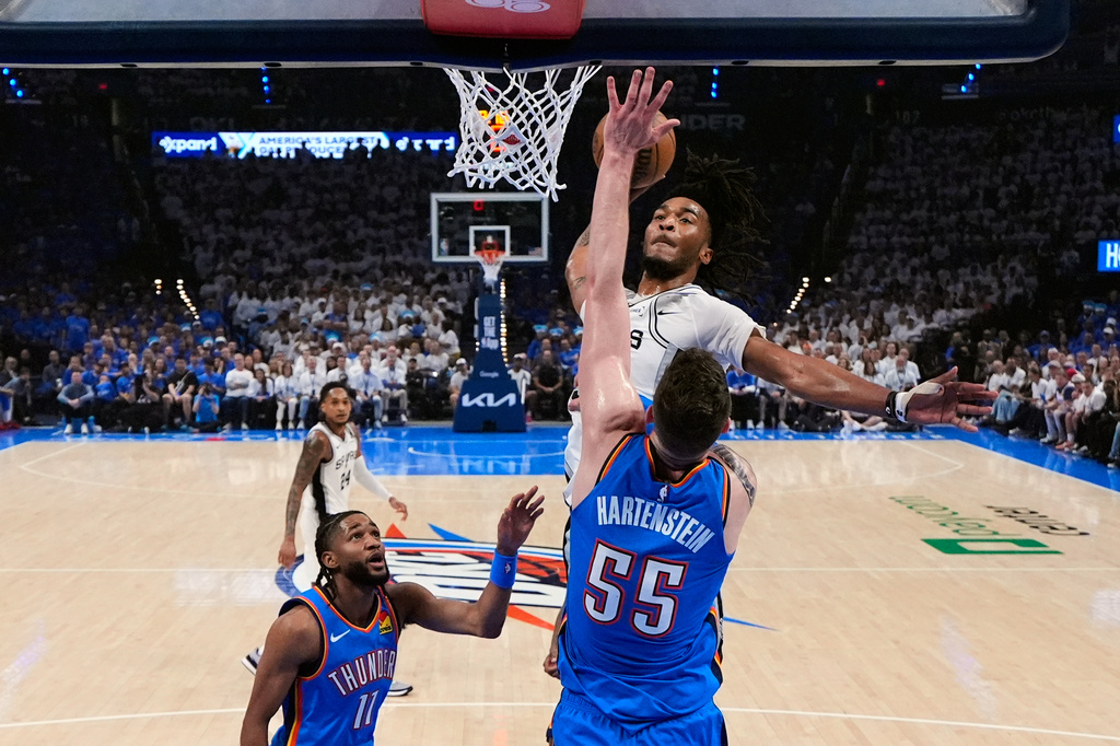 San Antonio Spurs guard Stephon Castle (5) dunks against Oklahoma City Thunder center Isaiah Hartenstein (55) during the first half of Game 2 in the Western Conference finals NBA basketball playoffs series Wednesday, May 20, 2026, in Oklahoma City. (AP Photo/Nate Billings)