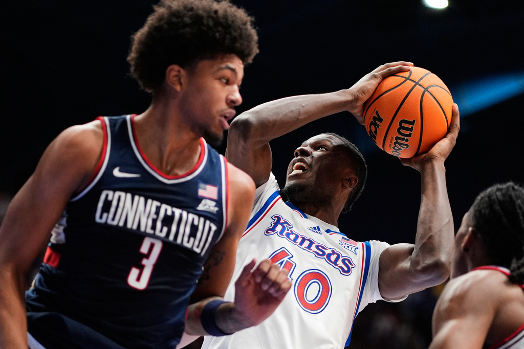 Kansas forward Flory Bidunga (40) shoots over UConn forward Jaylin Stewart (3) during the first half of an NCAA college basketball game Tuesday, Dec. 2, 2025, in Lawrence, Kan. (AP Photo/Charlie Riedel)