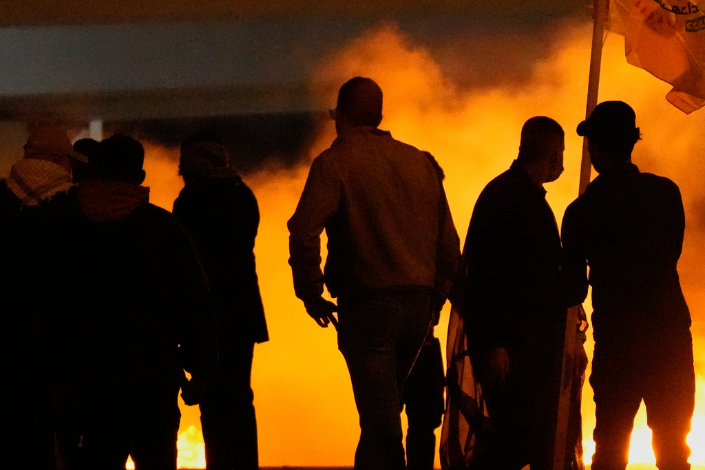 Security forces fire tear gas to disperse a protest against U.S. and Israeli attacks on Iran, at a bridge leading to the fortified Green Zone where the U.S. Embassy is located in Baghdad, Sunday, March 1, 2026. (AP Photo/Hadi Mizban)