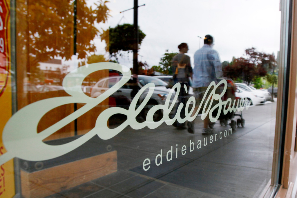 FILE - In this June 17, 2009, file photo, shoppers are reflected in the window as they walk past an Eddie Bauer store, in Seattle. (AP Photo/Elaine Thompson, File)