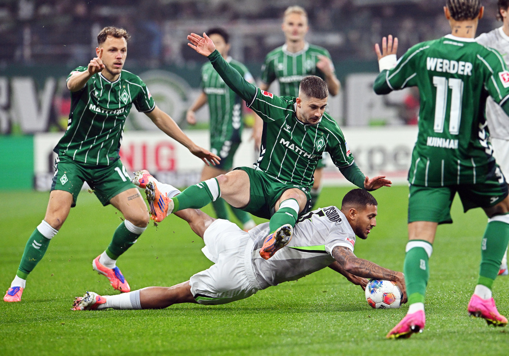 Bremen's Romano Schmid, top, fights for the ball against Wolfsburg's Vinicius Souza during the German Bundesliga soccer match between Werder Bremen and VfL Wolfsburg in Bremen, Germany, Friday, Nov. 7, 2025. (Carmen Jaspersen/dpa via AP)