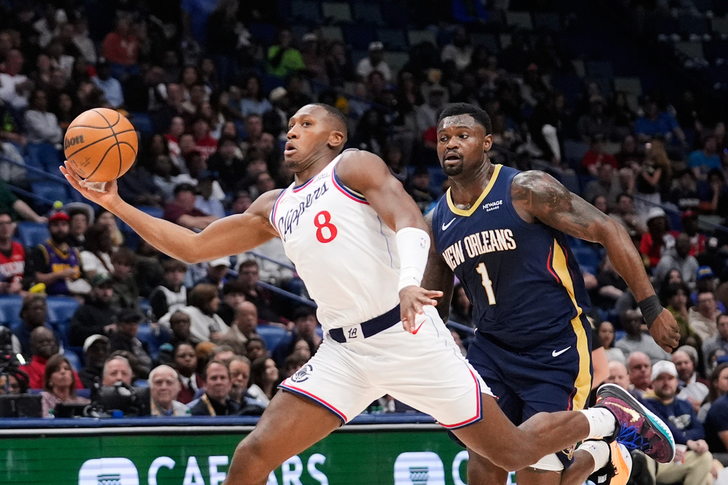 Los Angeles Clippers guard Kris Dunn (8) drives to the basket on a fast break against New Orleans Pelicans forward Zion Williamson (1) in the first half of an NBA basketball game, Wednesday, March 18, 2026, in New Orleans. (AP Photo/Gerald Herbert)