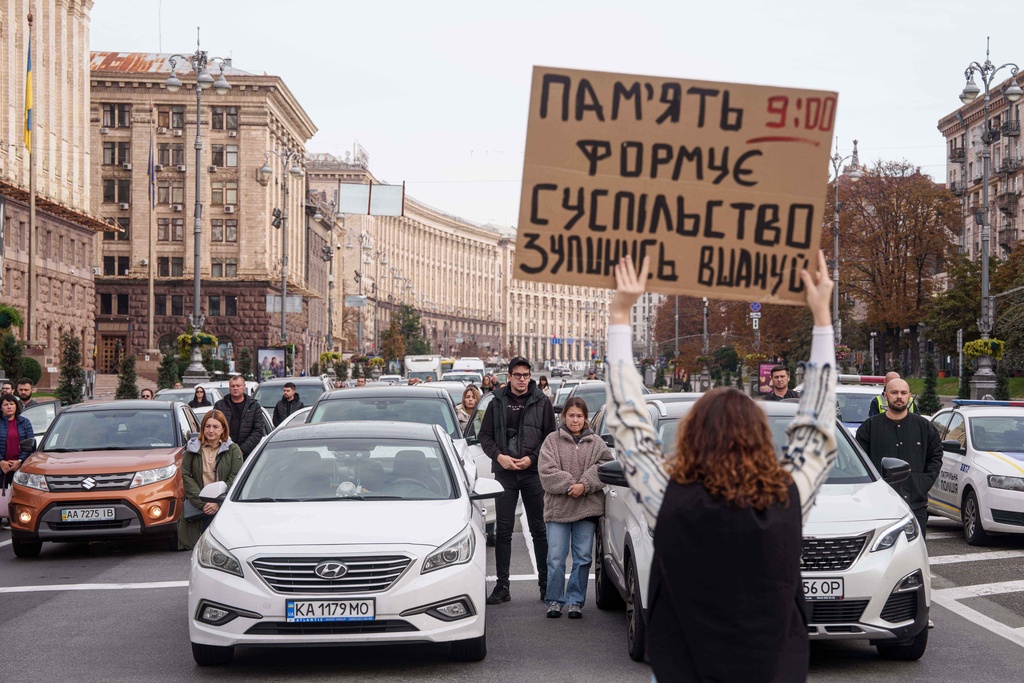 People stand by their cars during a nationwide minute of silence in memory of fallen soldiers, who defended their homeland in the war with Russia, in downtown Kyiv, Ukraine, Monday, Oct. 6, 2025. (AP Photo/Evgeniy Maloletka)