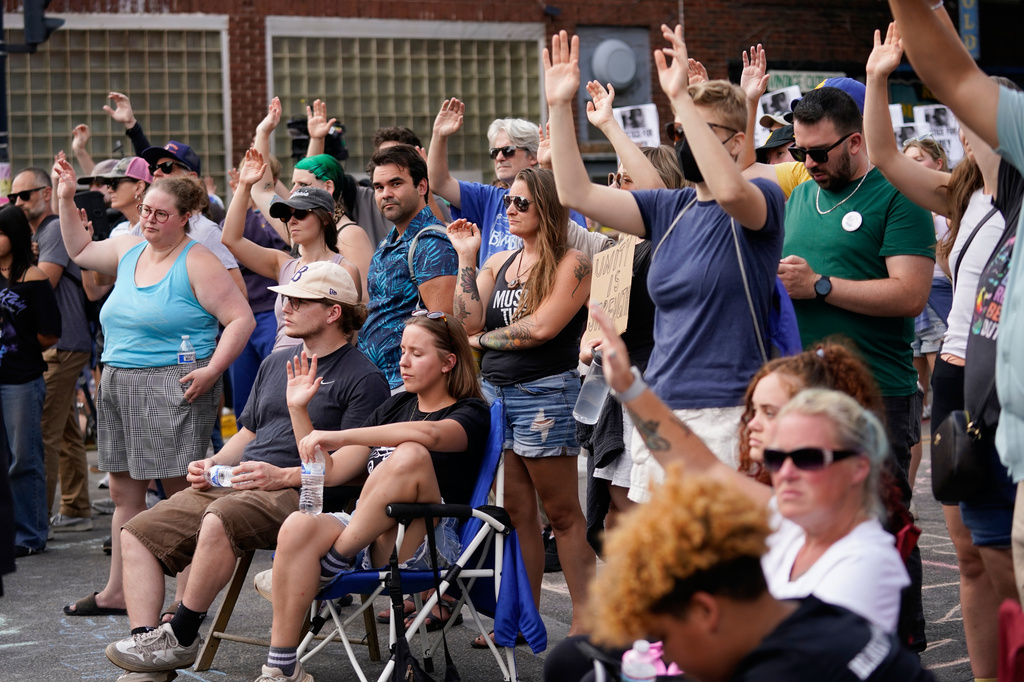 Attendees gesture as they gather at a memorial Thursday, July 23, 2026, in Madison, Wis., where a Madison police officer shot and killed Corey Durell Ruiz on Wednesday. (AP Photo/Kayla Wolf)