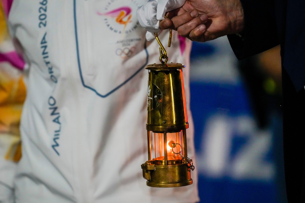 President of the Milano Cortina Organising Committee Giovanni Malago, right, and Italian Olympic medalist tennis player Jasmine Paolini hold a lantern with the Olympic flame as they arrive at Rome's International airport Leonardo da Vinci from Athens, Thursday, Dec. 4, 2025. (AP Photo/Gregorio Borgia)
