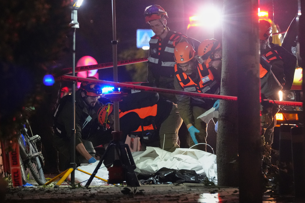 Israeli first responders remove the body of a person from the site of a missile strike in Tel Aviv, Israel, early Saturday, March 28, 2026. (AP Photo/Maya Levin)
