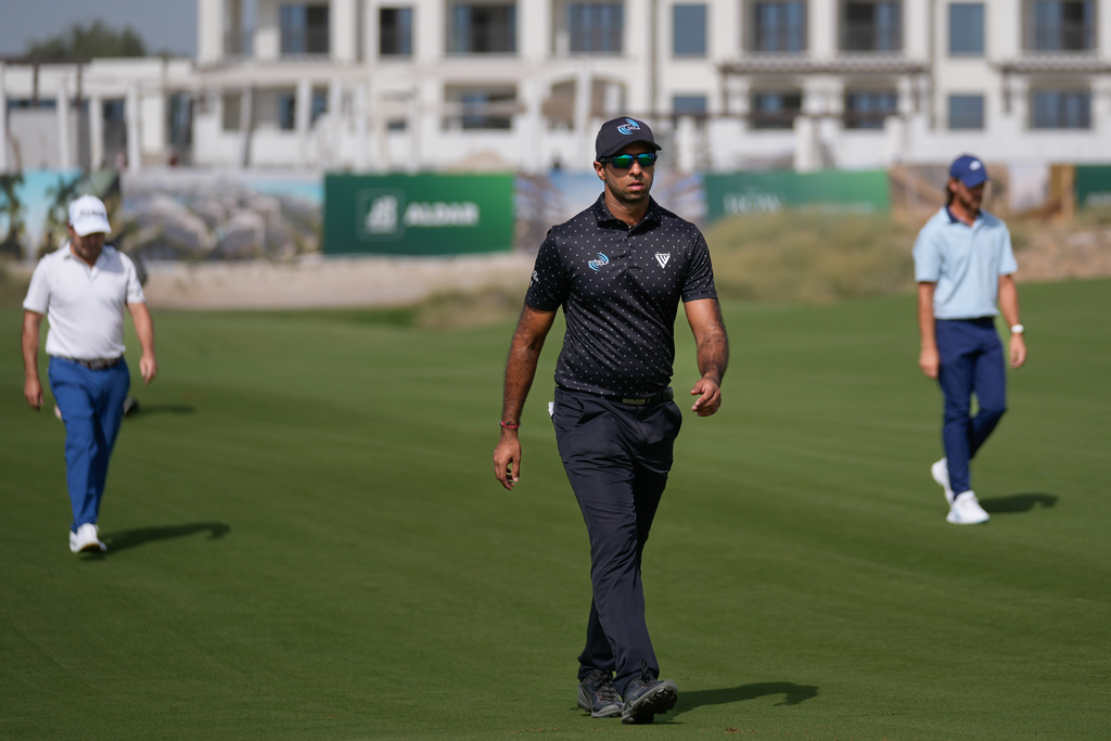 Aaron Rai of England, centre, walks ahead of Tommy Fleetwood of England, right, and Richard Sterne of South Africa, left, on 7th fairway during the third round of Abu Dhabi Golf Championship in Abu Dhabi, United Arab Emirates, Saturday, Nov. 8, 2025. (AP Photo/Altaf Qadri)