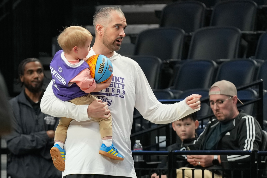 High Point head coach Flynn Clayman holds his son Quinn during practice prior to the first round of the NCAA college basketball tournament on Wednesday, March 18, 2026, in Portland, Ore. (AP Photo/Jenny Kane)