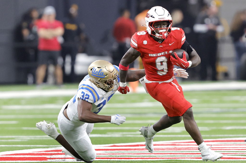 UNLV Rebels running back Jai'Den Thomas (9) avoids a tackle by UCLA Bruins linebacker Isaiah Chisom (32) during the first half of an NCAA college football game Saturday, Sept. 6, 2025, in Las Vegas. (Steve Marcus/Las Vegas Sun via AP)