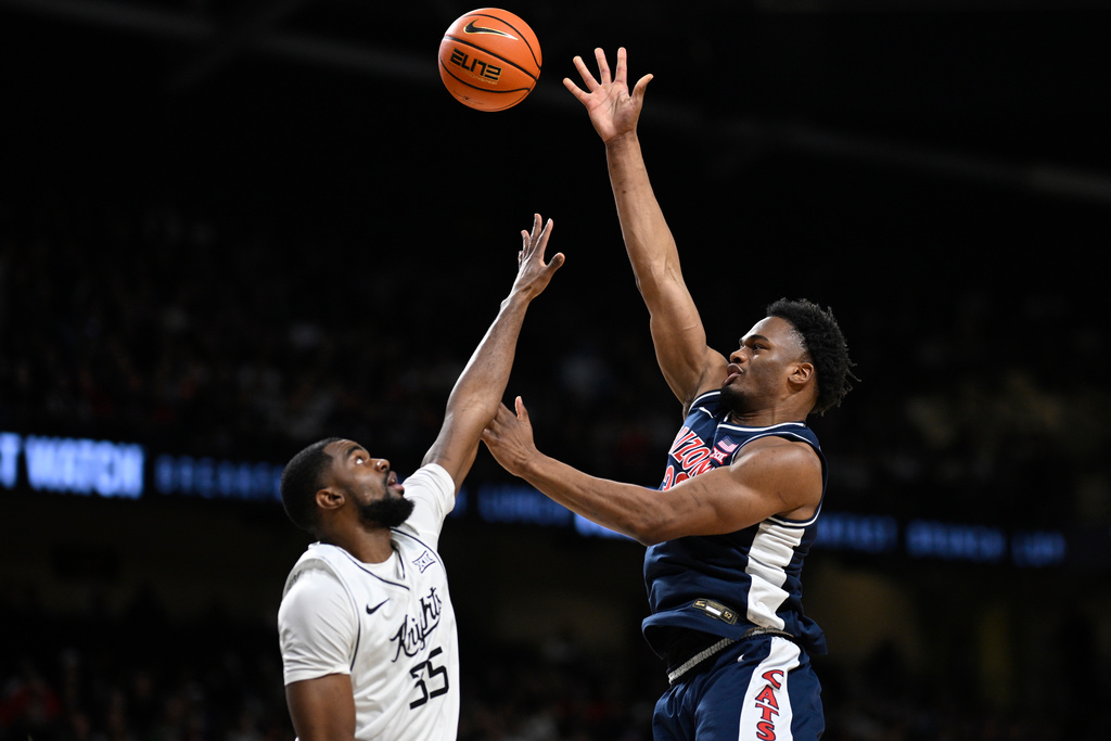 Arizona forward Tobe Awaka, right, shoots as Central Florida forward Devan Cambridge (35) defends during the first half of an NCAA college basketball game, Saturday, Jan. 17, 2026, in Orlando, Fla. (AP Photo/Phelan M. Ebenhack)