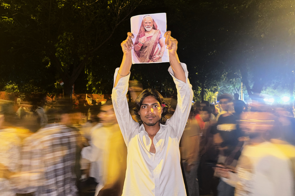 FILE- A protestor holds a placard with a portrait of Indian Prime Minister Narendra Modi draped in a saree, a traditional garment for women in India, during a demonstration demanding educational reforms as part of the Cockroach Janta Party's ongoing protest movement in New Delhi, India, Thursday, July 23, 2026. (AP Photo/Verda Subzwari, File)